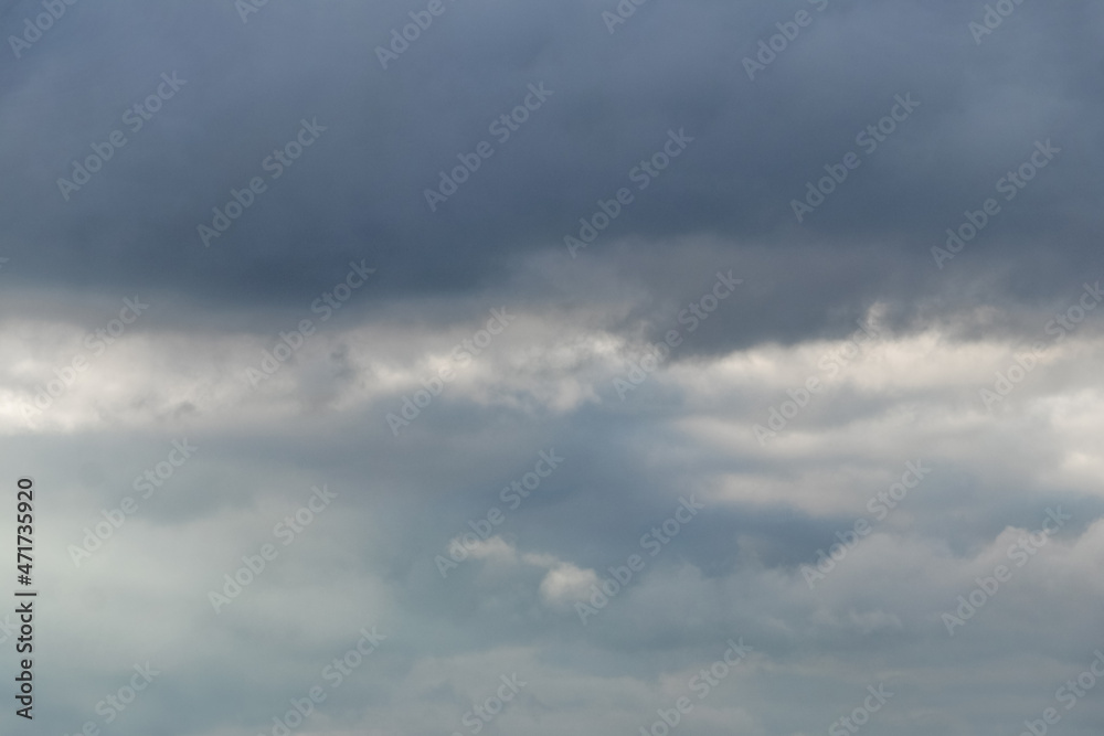 Dark heavy clouds in the blue sky, dramatic sky with dark storm clouds