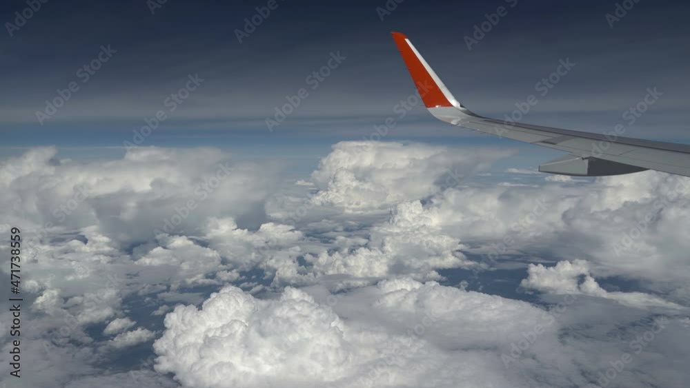 Airplane wing flies past a cloud. View from window of plane. Cumulus cloud near the wing. Beautiful view to the clouds Airplane wing flies past a cloud. View from window of plane. Cumulus cloud near the wing. Beautiful view to the clouds