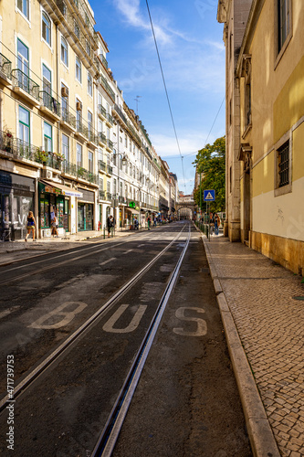 Krajobraz miejski, ciasne uliczki, tramwaje i tory tramwajowe w mieście Lizbona, Portugalia. #471739753