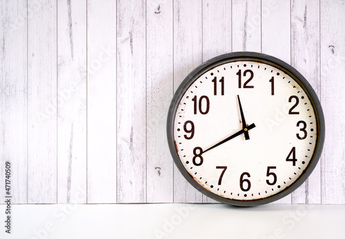Happy New Year's Eve farmhouse style large rustic clock against a white wood background backdrop.