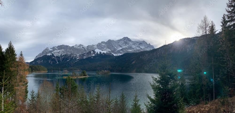 Eibsee in Autumn November with sunshine, trees and the Zugspitze mountain in the background, Bavaria Allgäu Germany
