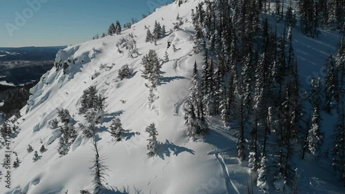 Fly past backcountry skier high up in the mountains