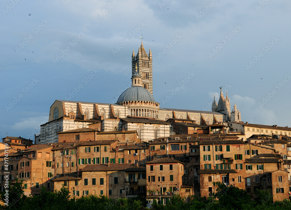 Cityscape Of Siena in Tuscany Italy With The Famous Cathedral On A Beautiful Spring Day With A Blue Sky And A Few Clouds