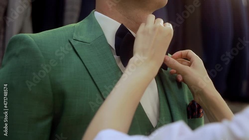Businessman. Women's hands straighten a bow tie. Male accessory, elegant style. Getting ready for the event.