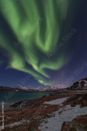 Northern Lights dancing above the fjord in Tromsø, Norway
