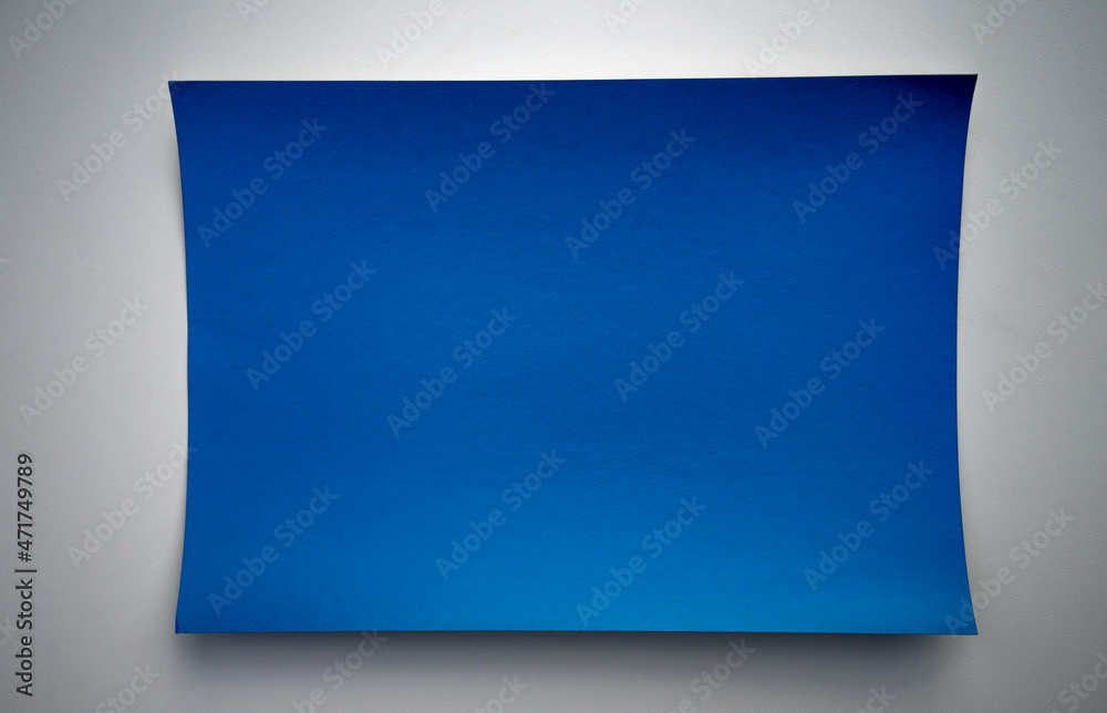 A blue sheet of paper on a white table. Blue cardboard on a white isolate. Blue background for the inscription. The form is on the table.