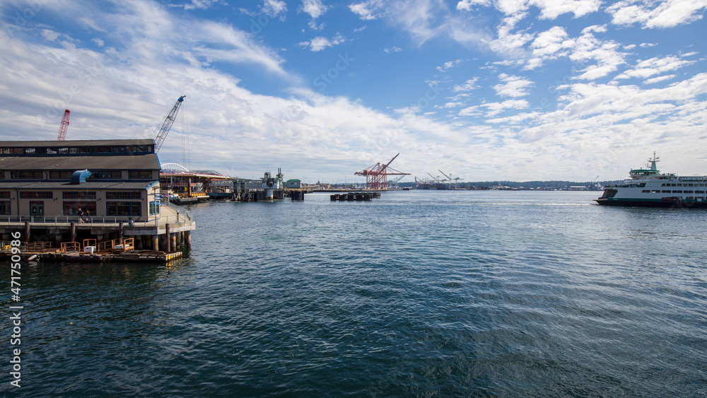 Seattle, Washington, USA - June 4 2021: Mount Rainier and Seattle Logistics shipping terminals waterway. View from Elliott Bay during summer.