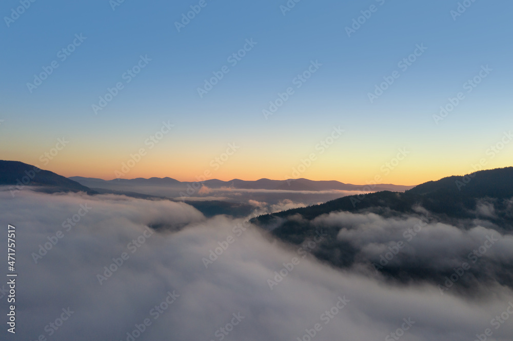 Beautiful landscape with thick mist in mountains at sunset. Drone photography