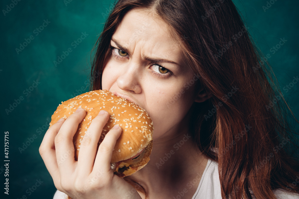 woman eating hamburger fast food snack close-up woman eating hamburger fast food snack close-up