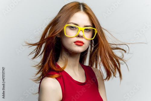 emotional woman in red dress yellow glasses posing