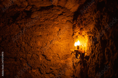 Dim yellow light from a dim lamp in a stone cave