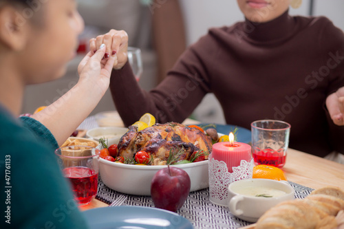 Happy African family holding hands and praying dinner on thanksgiving eve day together  merry Christmas  celebration and festive on food table  relationship of family  indoor  new year and xmas.