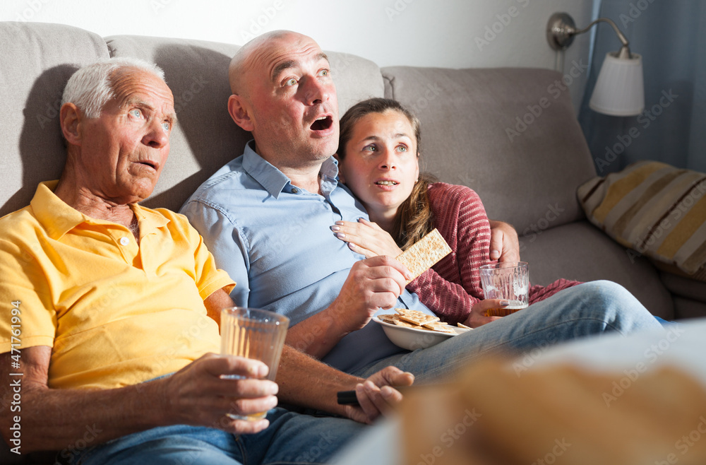 Obraz premium Family watching tv and drinking beer at home. High quality photo