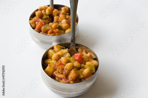 Delicious Indian chaat (salad) made of chickpeas, fruits, tomatoes, onion and different masalas in steel bowl ready to eat