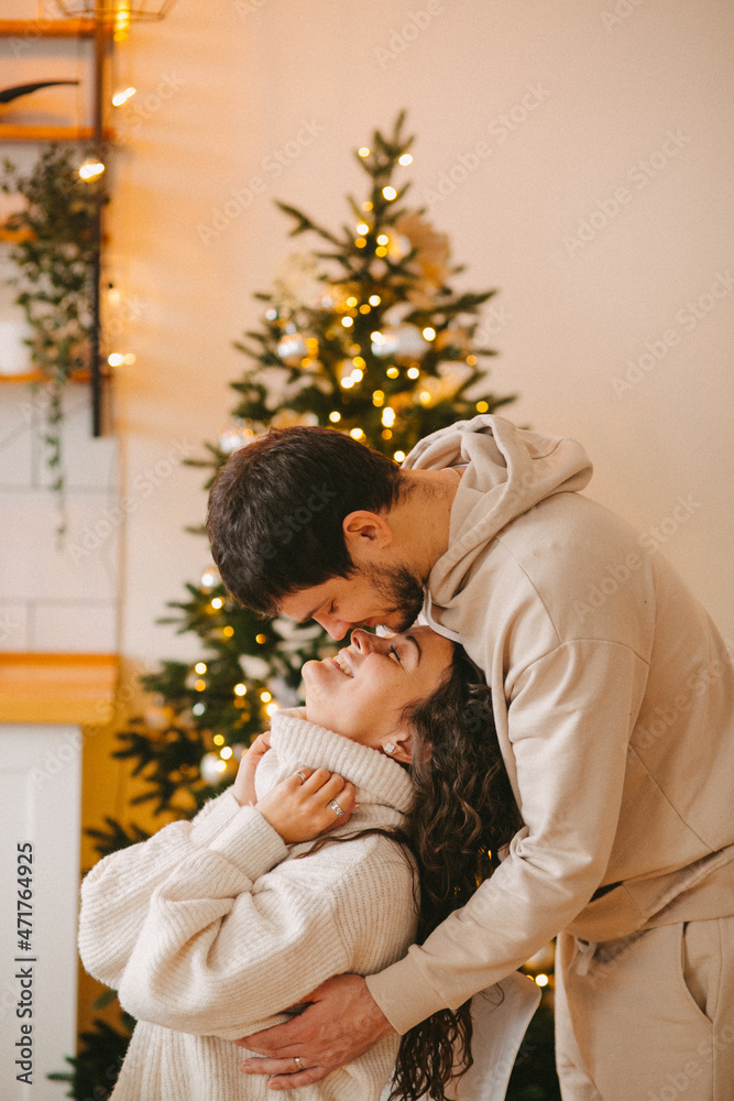 Young couple in a house in a romantic winter landscape in a christmas interior. Young couple in a house in a romantic winter landscape in a christmas interior.