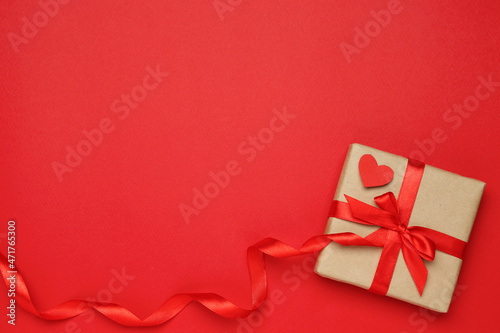 Beautiful gift box with decorative heart on red background, top view. Space for text