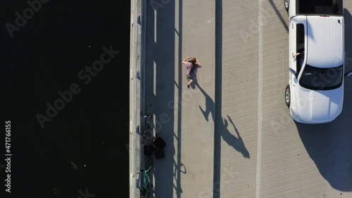 Person skateboarding on coastal asphalt sideway and road, top down aerial view