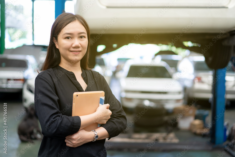 Satisfied Asian young woman in black shirt showing a thumb up in garage. Satisfied Asian young woman in black shirt showing a thumb up in garage.