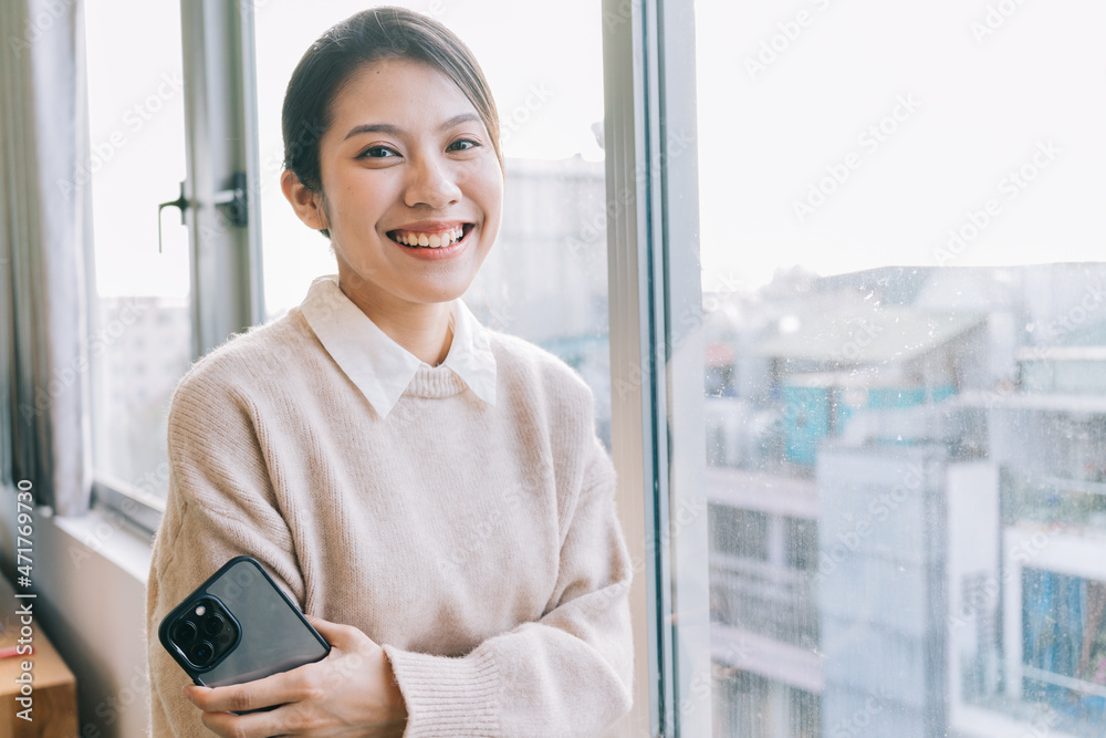 Young Asian woman using smartphone at home
