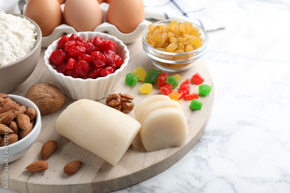 Marzipan and other ingredients for homemade Stollen on white marble table. Baking traditional German Christmas bread Marzipan and other ingredients for homemade Stollen on white marble table. Baking traditional German Christmas bread