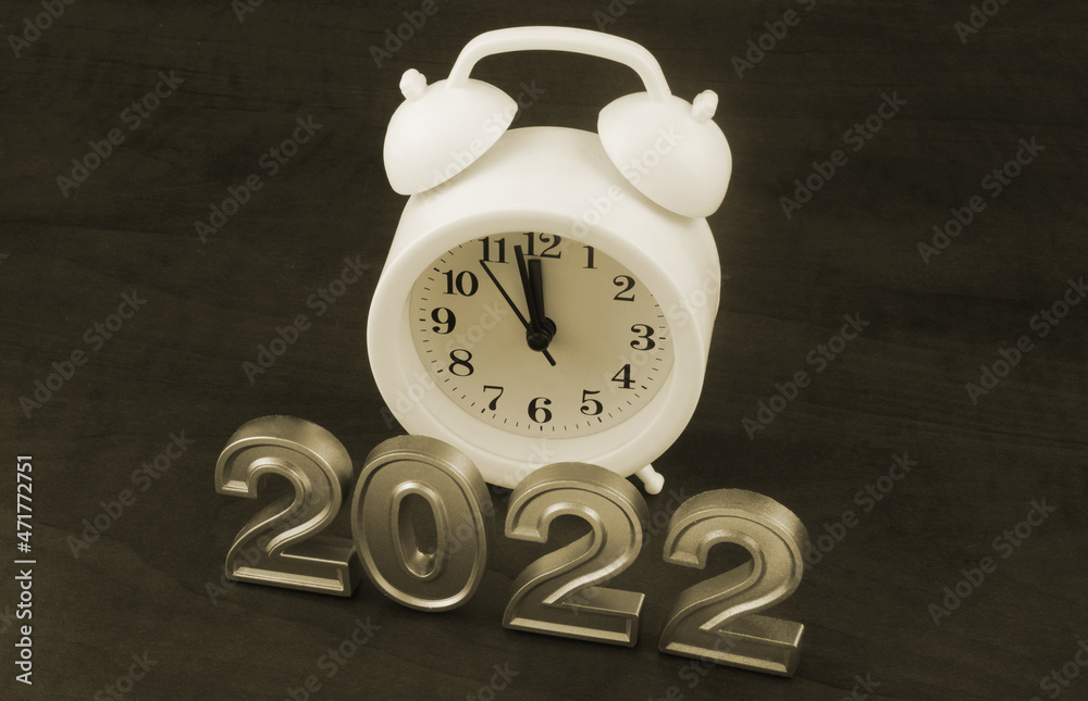 Alarm clock and numbers 2022 on wooden background Alarm clock and numbers 2022 on wooden background