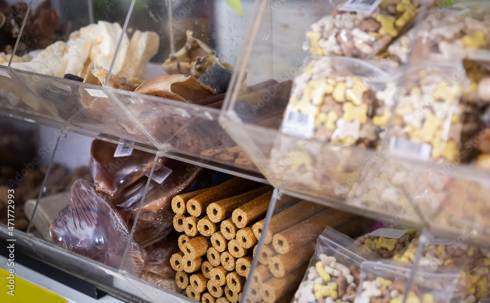 Closeup of various dog feed and treats on showcase in pet store.