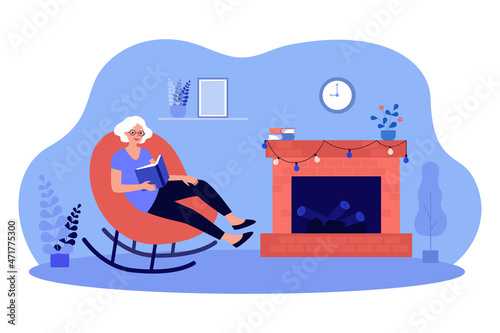 Fototapeta Grandmother holding book sitting in rocking chair by fireside