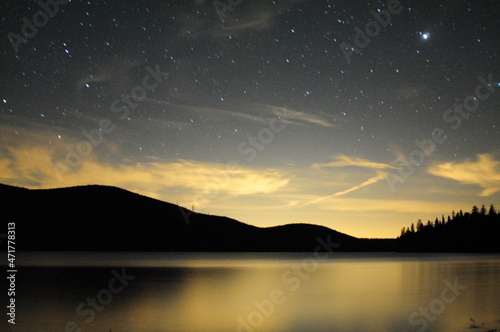 Night sky with hills and lake reflection