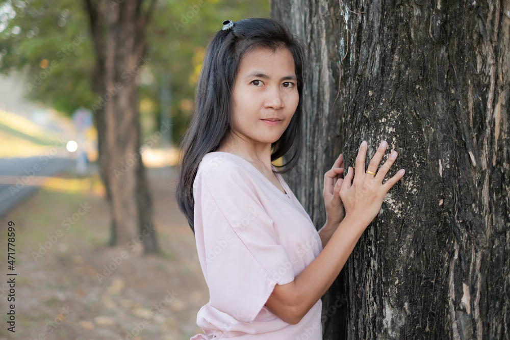 Portrait alone woman standing with big tree nature in park. lonely or broken heart concept. authentic slim fit, black hair and skin tan asian thailand. Portrait alone woman standing with big tree nature in park. lonely or broken heart concept. authentic slim fit, black hair and skin tan asian thailand.