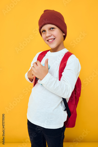 Cool smiling boy with red backpack red skateboard isolated background © SHOTPRIME STUDIO