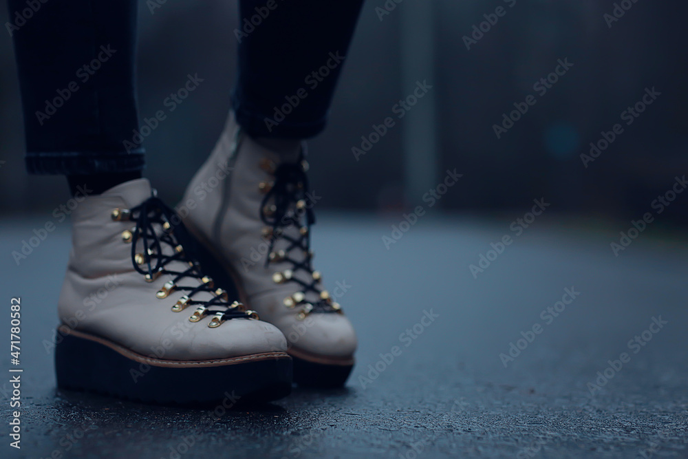 feet in winter boots walk in the park, abstract seasonal background, November weather