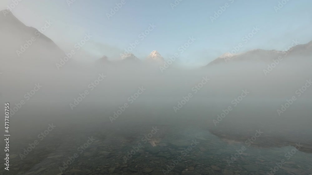 Mount Assiniboine in blue foggy reflection on Lake Magog at Provincial park Mount Assiniboine in blue foggy reflection on Lake Magog at Provincial park
