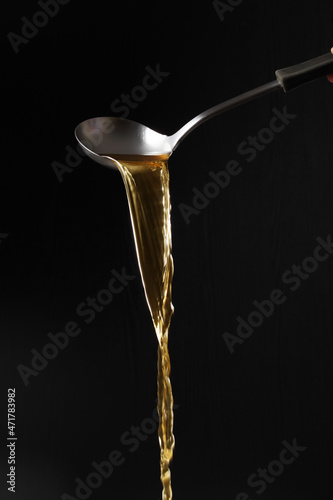 Dipper pouring noodle soup isolated on black background