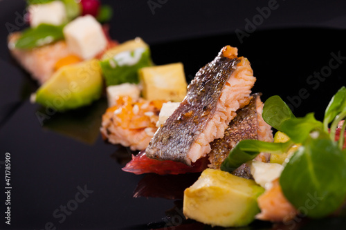 Delicious colorful salad with grilled trout, avocado, grapefruit, feta cheese and corn salad