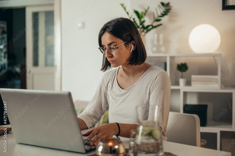 Beautiful woman using a laptop while working from home Beautiful woman using a laptop while working from home