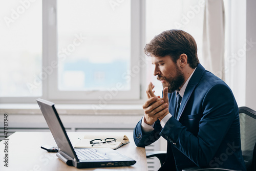 man in a suit in the office in front of a laptop executive manager