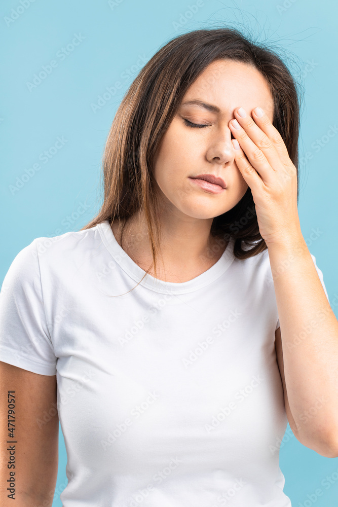 Young woman with headache and pain touches her head and eyes Young woman with headache and pain touches her head and eyes