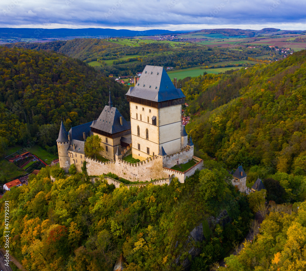 Picturesque autumn landscape with imposing medieval Karlstejn Castle on hilltop above village of same name, Czech Republic