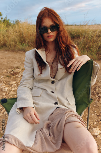 woman sitting on a chair in a field wearing dark glasses endless field © SHOTPRIME STUDIO