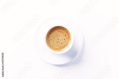 Cup of coffee on bright paper background. Top view. Close up. Copy space.