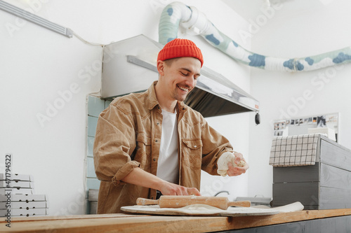young man makes the dough for pasta