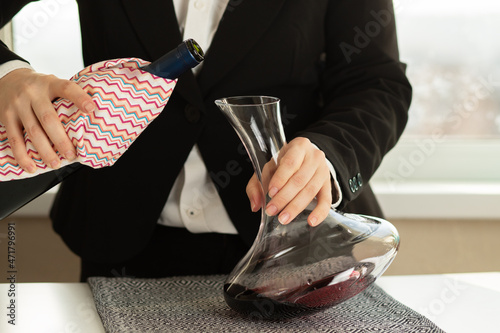 waiter pours wine into decanter,saturation of the drink with oxygen,precipitation