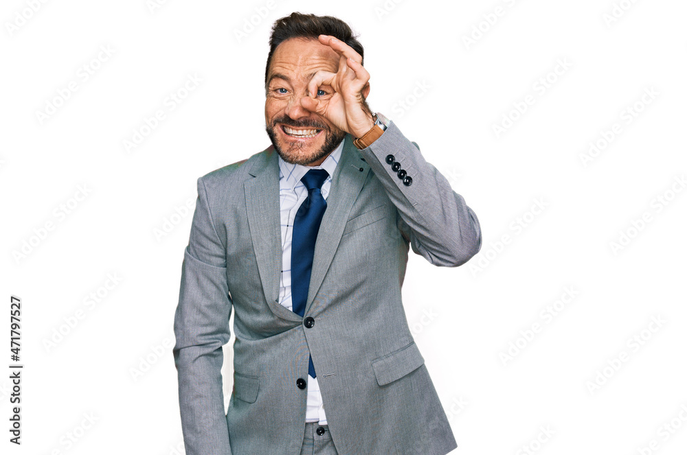 Middle age man wearing business clothes doing ok gesture with hand smiling, eye looking through fingers with happy face.