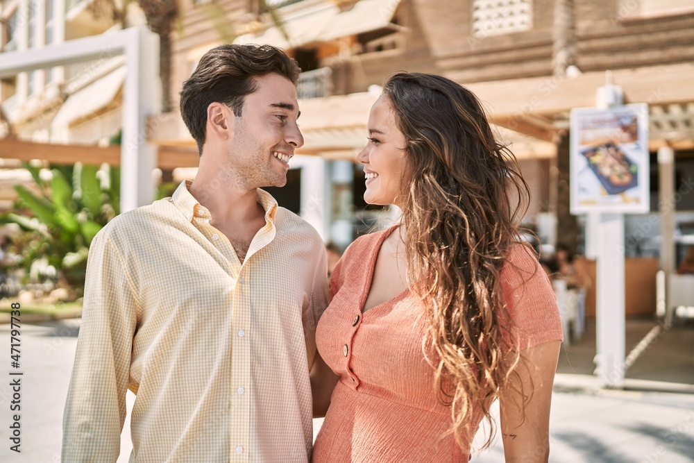 Naklejka premium Man and woman couple smiling confident and hugging each other at street