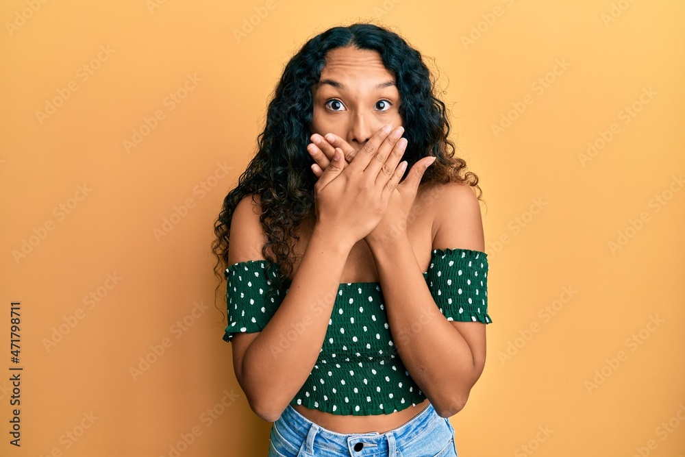 Young latin woman wearing casual clothes shocked covering mouth with hands for mistake. secret concept. Young latin woman wearing casual clothes shocked covering mouth with hands for mistake. secret concept.