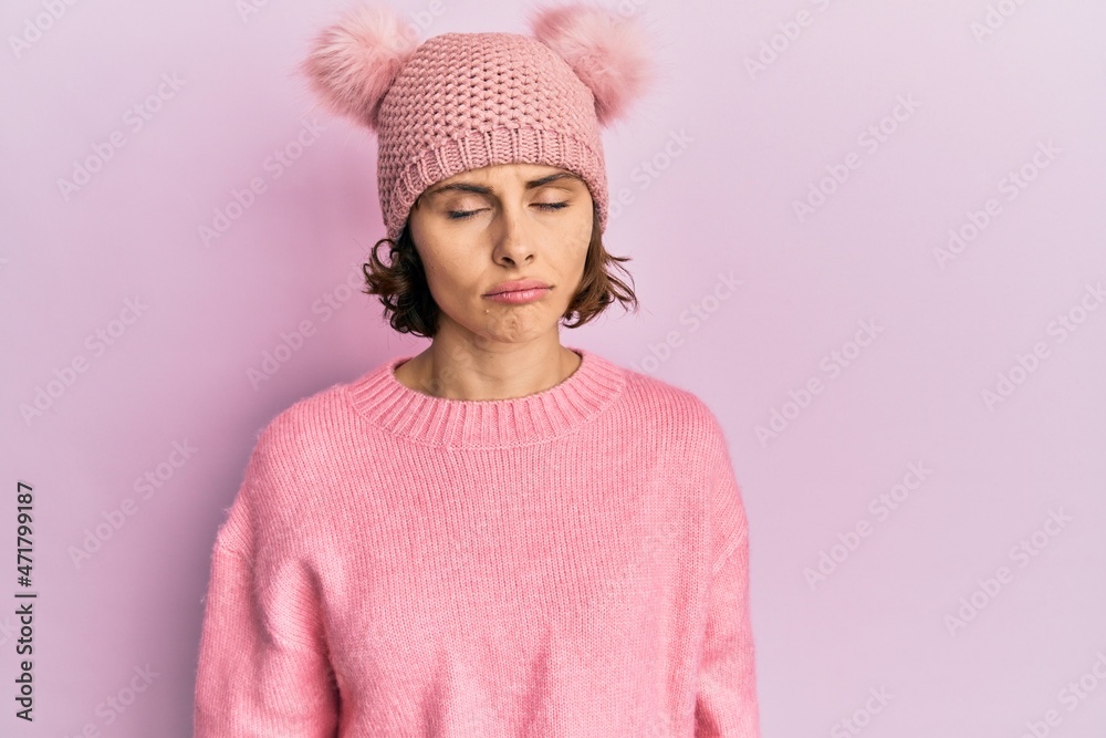 Young brunette woman wearing cute wool cap depressed and worry for distress, crying angry and afraid. sad expression. Young brunette woman wearing cute wool cap depressed and worry for distress, crying angry and afraid. sad expression.