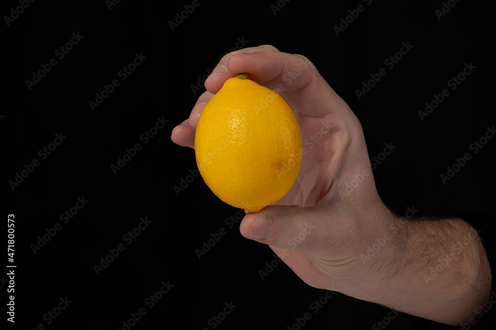 lemon in hand isolated on black background lemon in hand isolated on black background