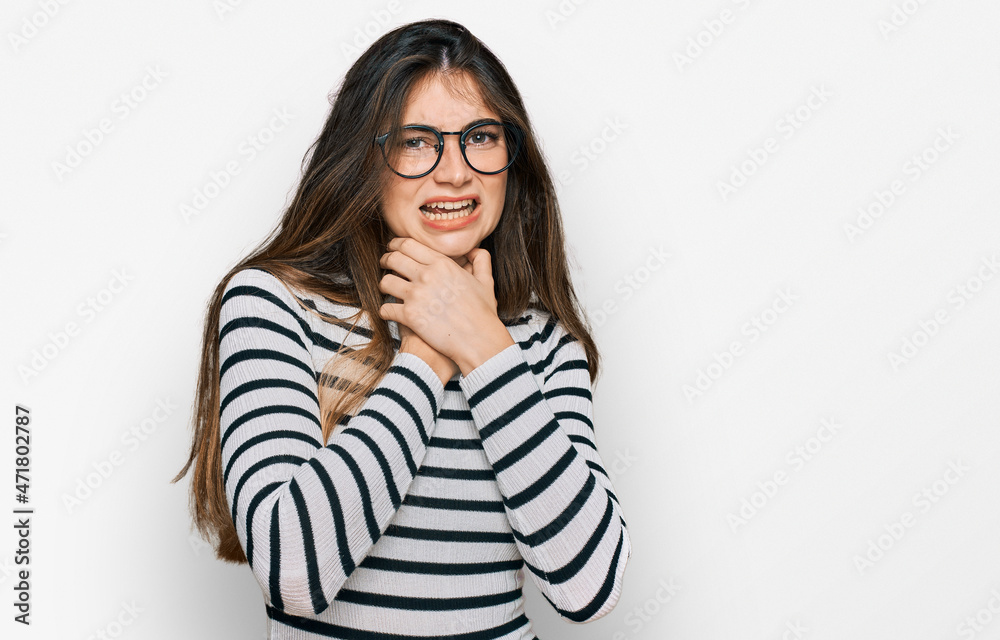 Young beautiful teen girl wearing casual clothes and glasses shouting and suffocate because painful strangle. health problem. asphyxiate and suicide concept. Young beautiful teen girl wearing casual clothes and glasses shouting and suffocate because painful strangle. health problem. asphyxiate and suicide concept.