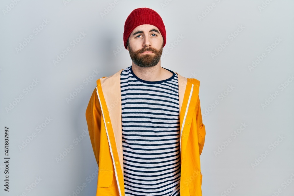 Caucasian man with beard wearing yellow raincoat depressed and worry for distress, crying angry and afraid. sad expression.