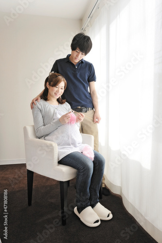 編み物をする妊婦と寄り添う夫 © ＭＯＭＯＴＡＲＯＵ